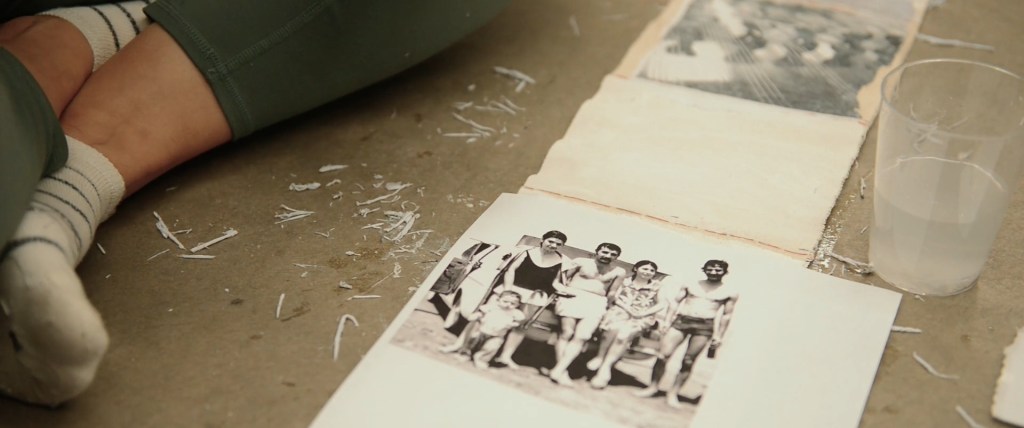 Still from Exile Echoes (2024) by Mazyar Mahan: an old group photograph transferred onto paper on the studio floor.