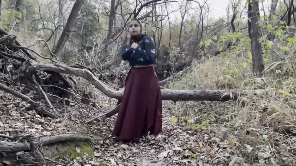 Still from Fear (2021) by Mazyar Mahan: the dancer stands motionless in the bare woods.