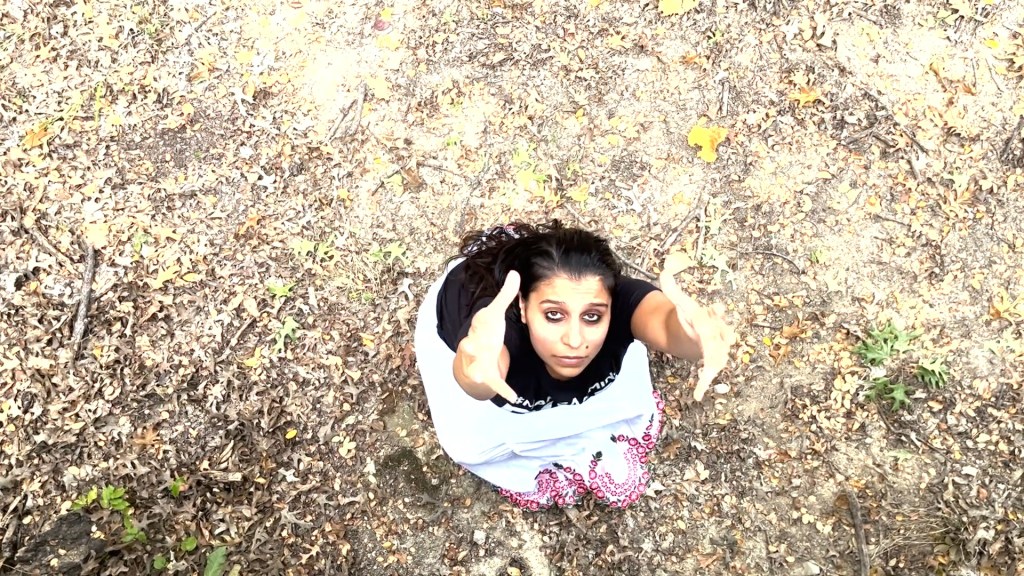 Still from For Freedom (2022) by Mazyar Mahan: seen from above, the dancer looks up from the stony ground.