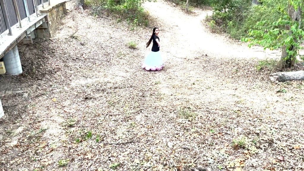 Still from For Freedom (2022) by Mazyar Mahan: a small figure dances alone at the bend of a dirt path.