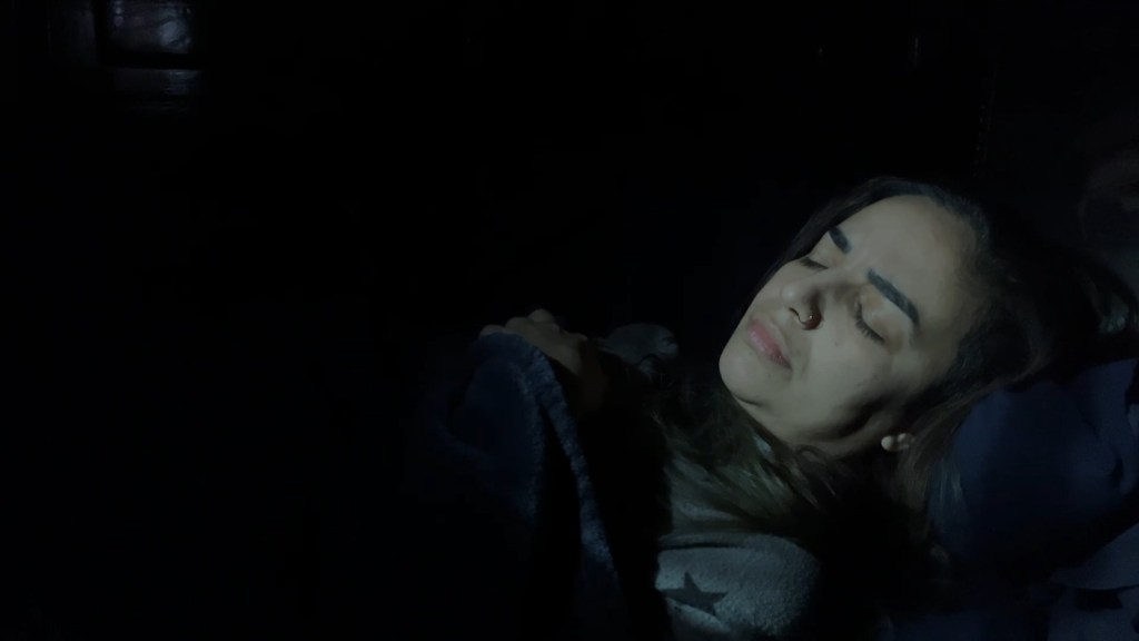 Still from Return of the Repressed (2023) by Mazyar Mahan: a woman asleep in the dark, at the start of a dream.