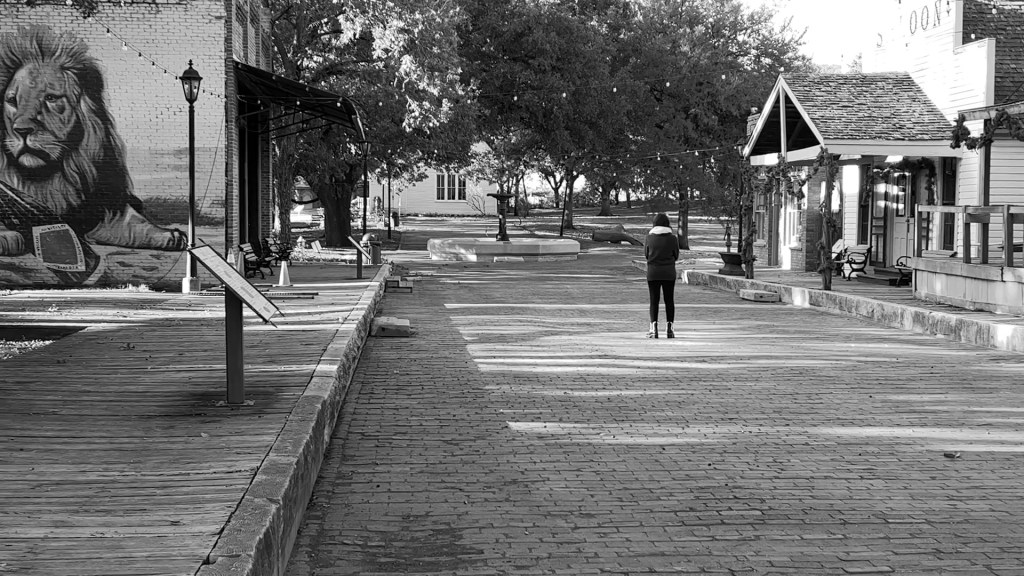 Still from Return of the Repressed (2023) by Mazyar Mahan: a lone figure at the far end of an empty town street.